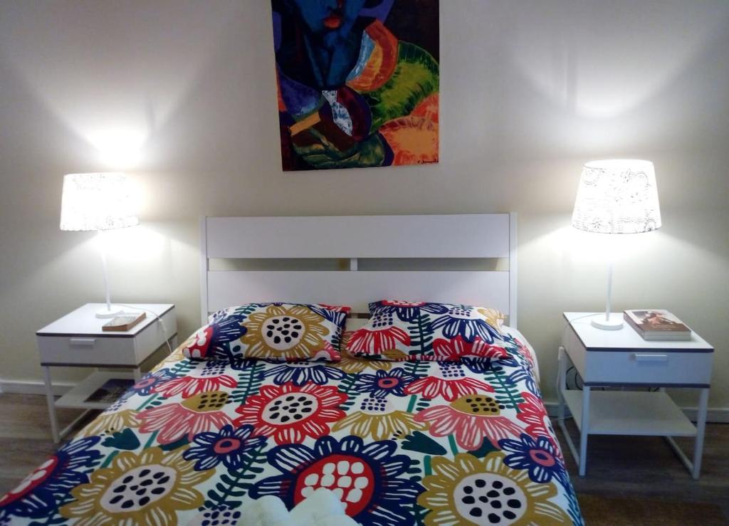 a bedroom with a bed and two night stands with lamps at Famille au Cœur de Lisbonne in Lisbon