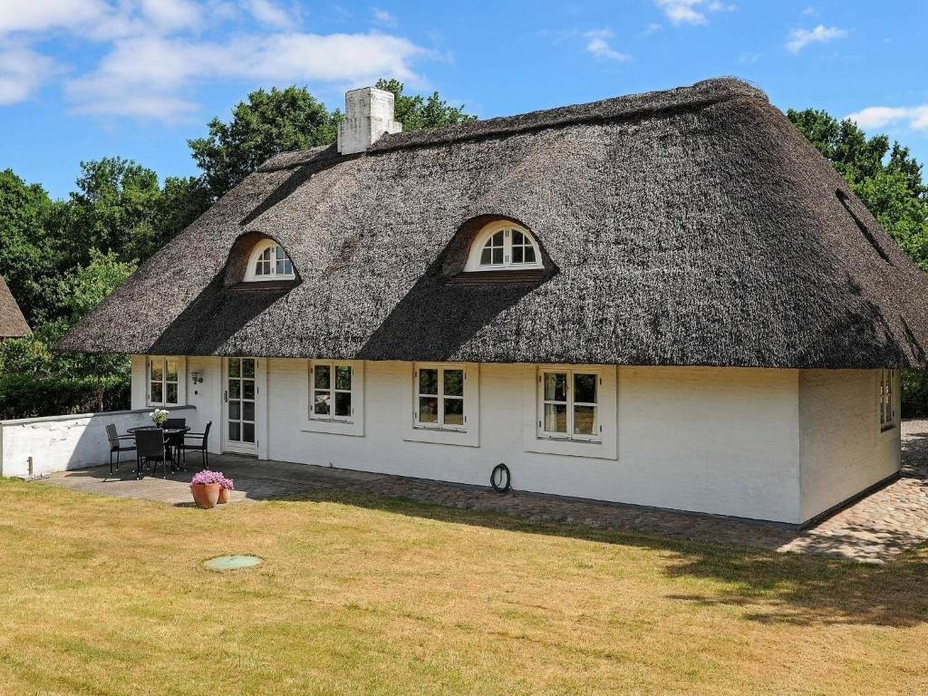 a thatch roofed house with a thatched roof at Holiday home Asperup II in Asperup