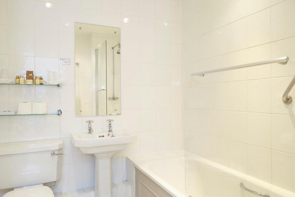 a white bathroom with a sink and a toilet at The Royal Hotel in Ventnor