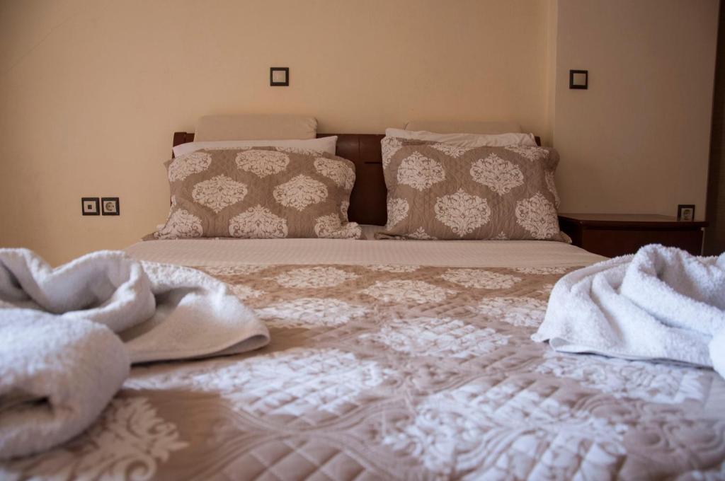 a bed with white sheets and pillows on it at Minas-Maria House in Karpathos