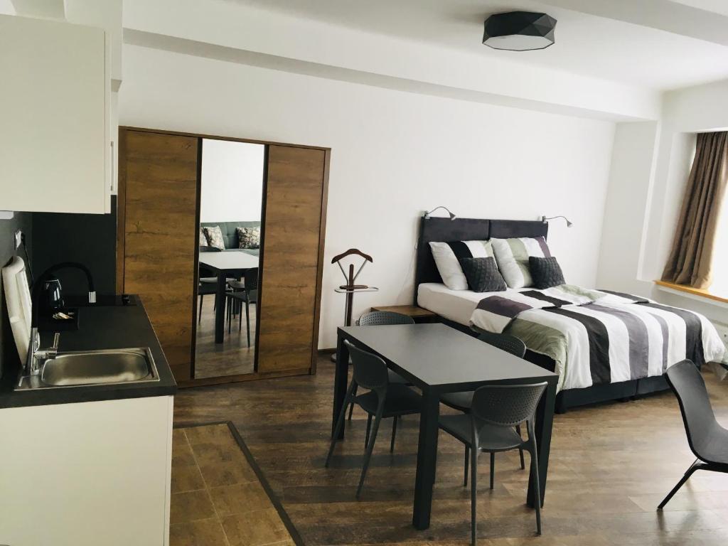 a bedroom with a bed and a table and a sink at Like Home Apartments Prague in Prague