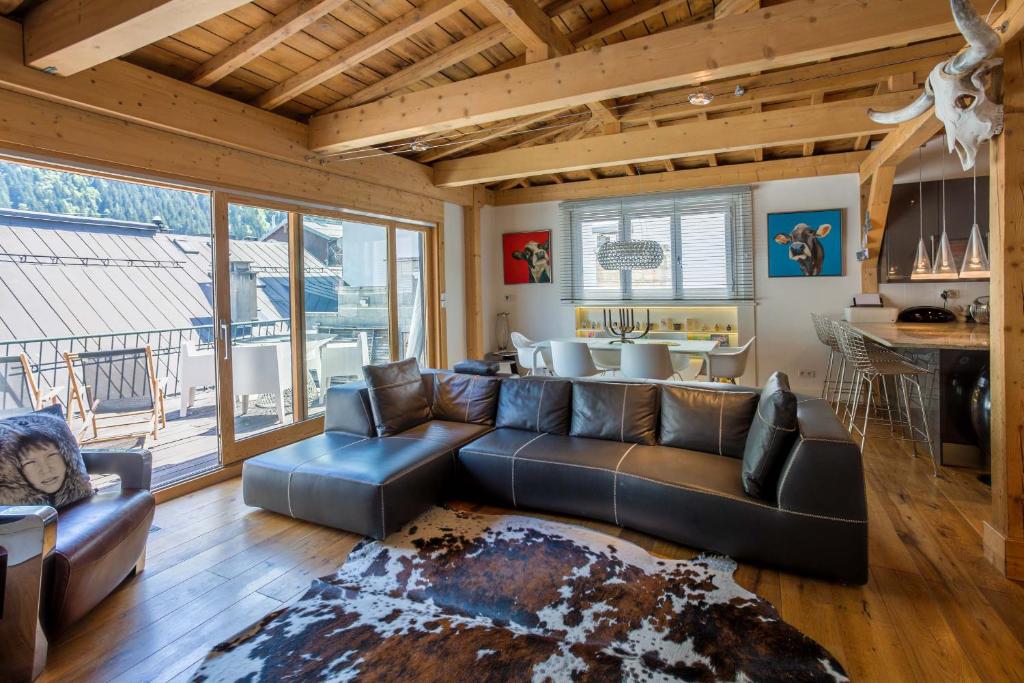 ein Wohnzimmer mit einem Sofa und einem Tisch in der Unterkunft Penthouse le Bartavel - Chamonix All Year in Chamonix-Mont-Blanc