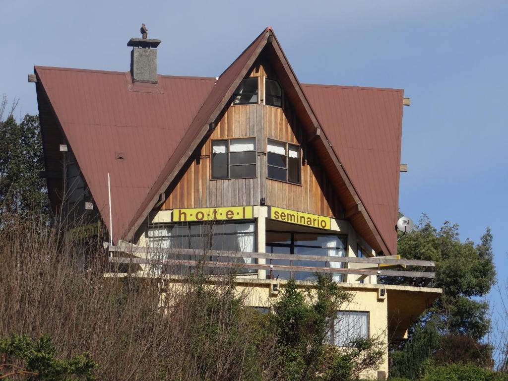 una casa de madera con techo de gambrel en Hotel Seminario, en Puerto Montt