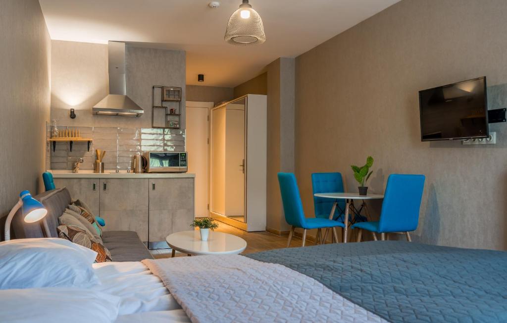 1 dormitorio con 1 cama y cocina con sillas azules en New Gudauri, Red Co. Loft 2., en Gudauri