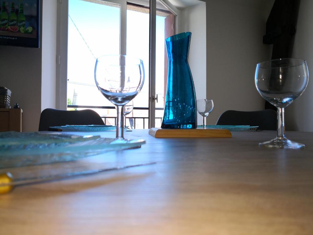 three wine glasses sitting on a wooden table at Appartement Rue Haute des Bains in Le Croisic