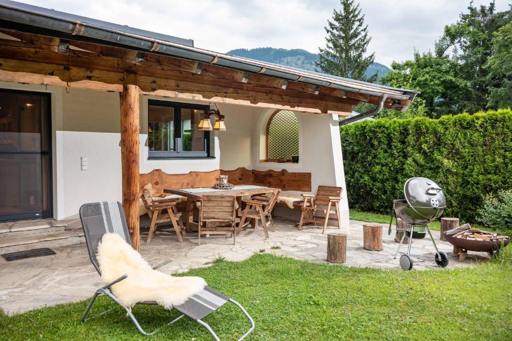 een patio met een tafel en stoelen in een tuin bij Exclusive Appartement Chalet in Sankt Johann in Tirol