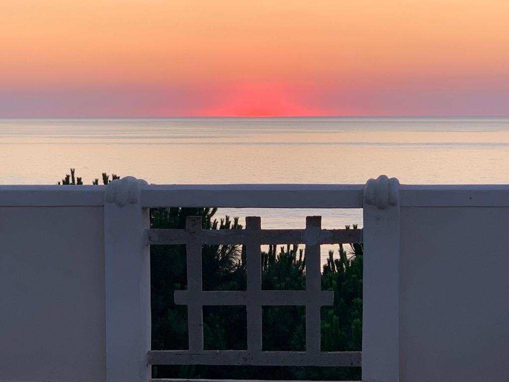 a white gate with the sunset in the background at Villino Eleonora in Parghelia