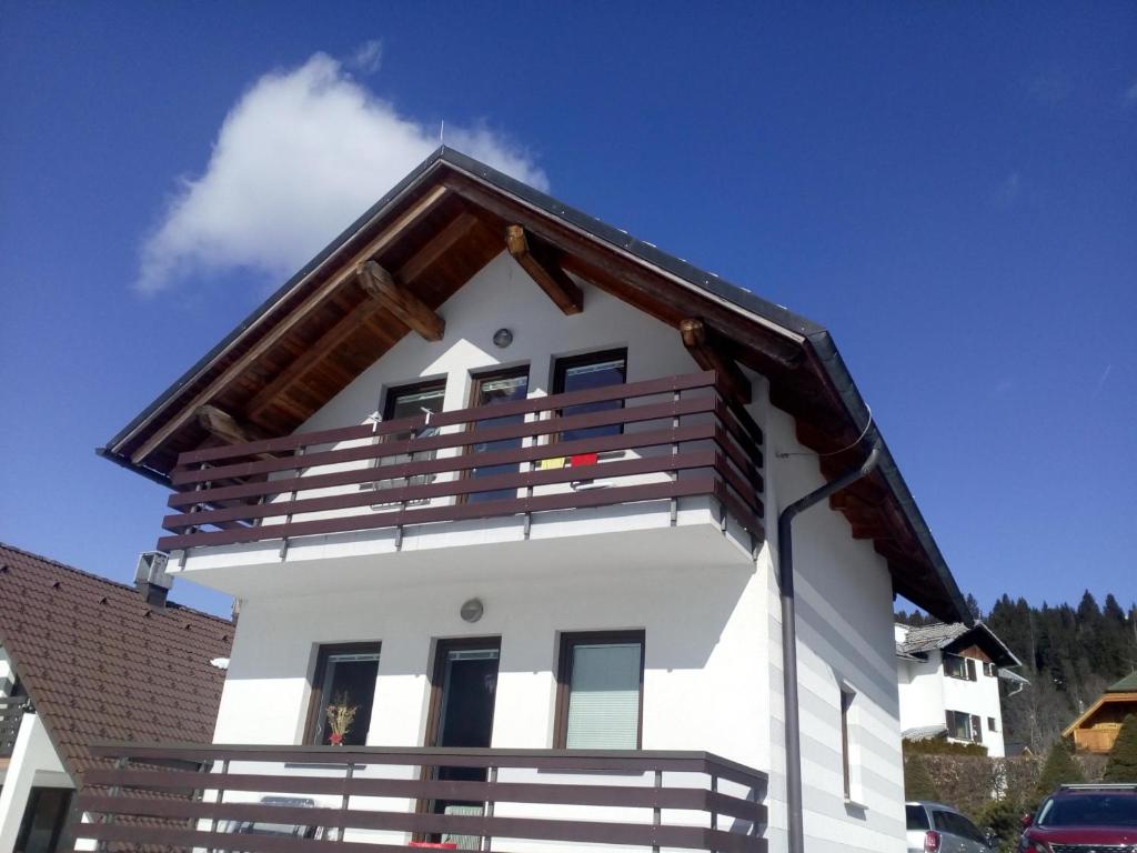 a white house with a brown roof at JULIJA 3 SUNNY APPARTMENT in Kranjska Gora