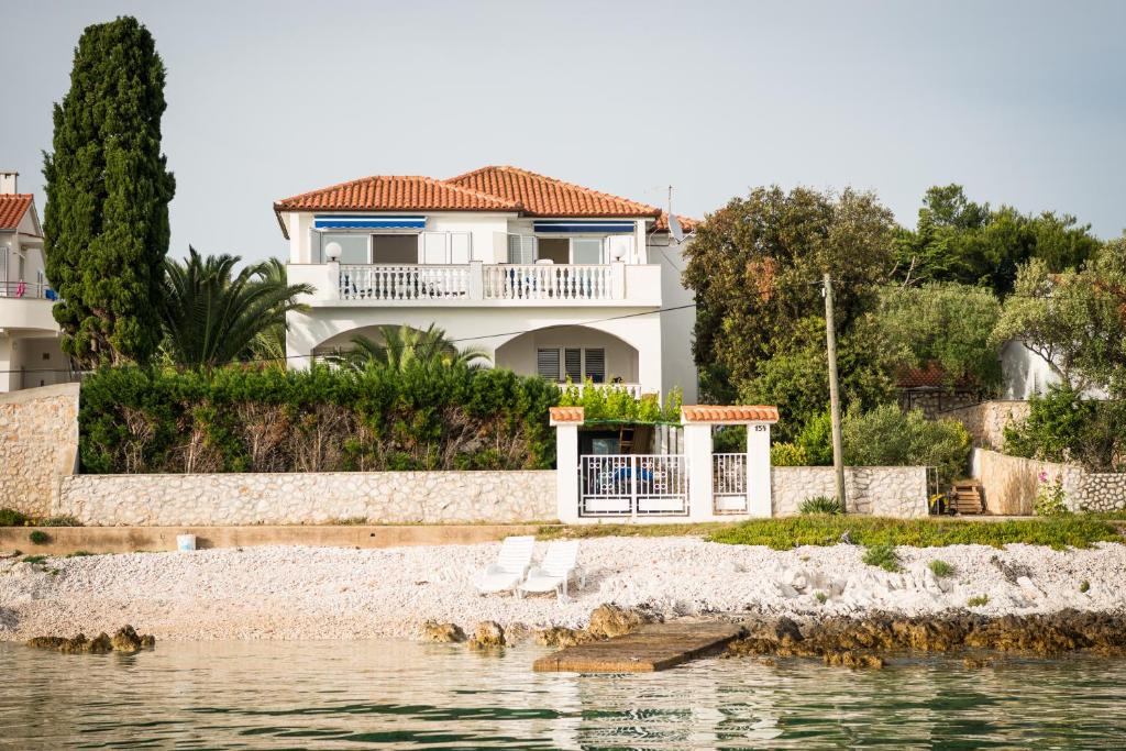 uma casa na costa de um corpo de água em La Villa-Silba em Silba