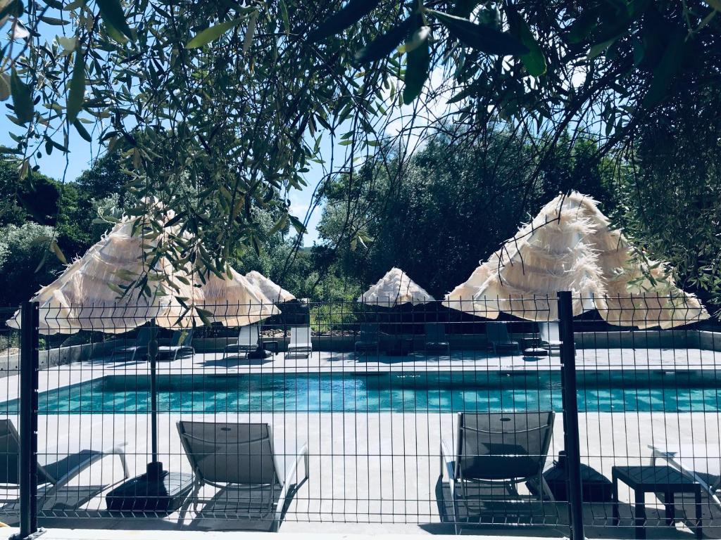 - un groupe de chaises longues et de parasols à côté de la piscine dans l'établissement Gite U Licetu A la Campagne, à Oreta