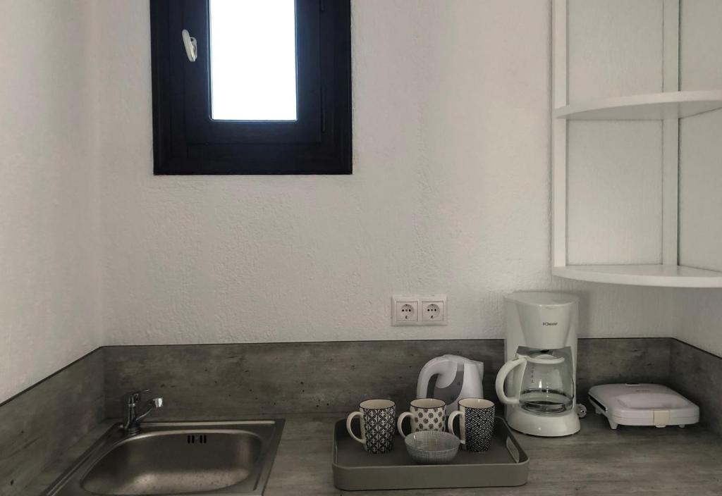 a kitchen counter with a sink and a coffee maker at Villa Spartias in Skiathos
