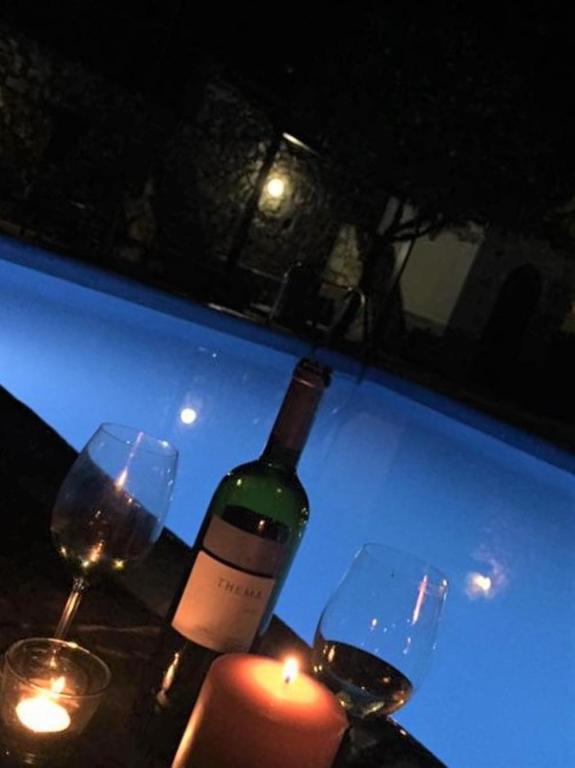 a bottle of wine and two glasses on a table at Villa Spartias in Skiathos