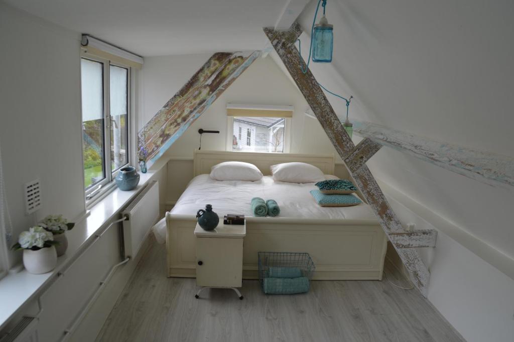 um pequeno quarto com uma cama no sótão em Bijzonder Bakkum em Castricum