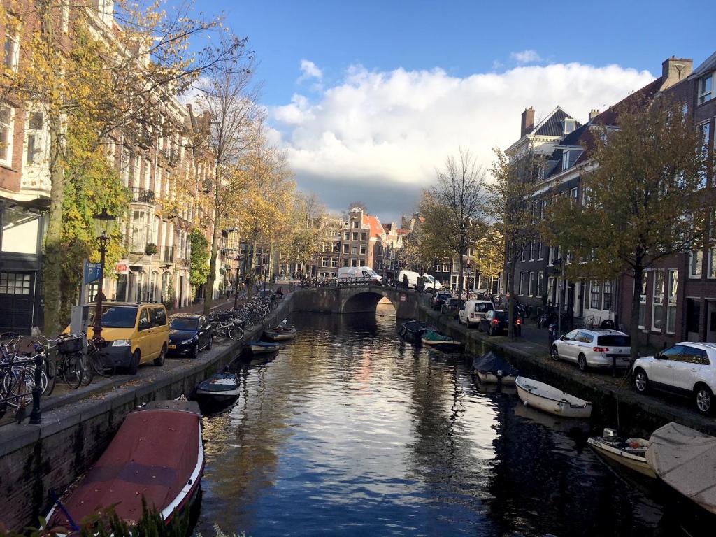 un río con barcos en una ciudad con edificios en B&B Looier, en Ámsterdam