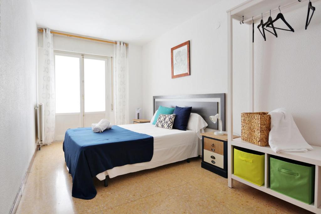een slaapkamer met een bed met een blauwe deken bij TorreNueva in Zaragoza