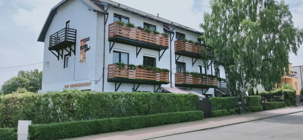 a white building with flower boxes on the windows at Dom Wczasowy Elsta Vita in Władysławowo