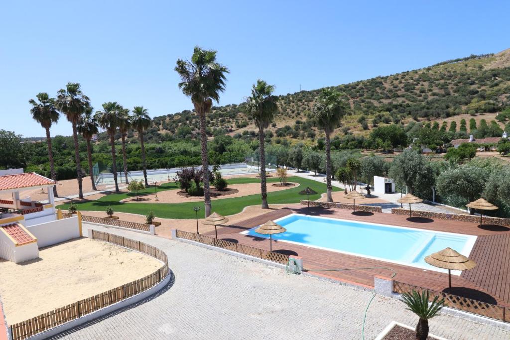 Blick auf den Pool in einem Resort mit Palmen in der Unterkunft Monte da Graça in Elvas