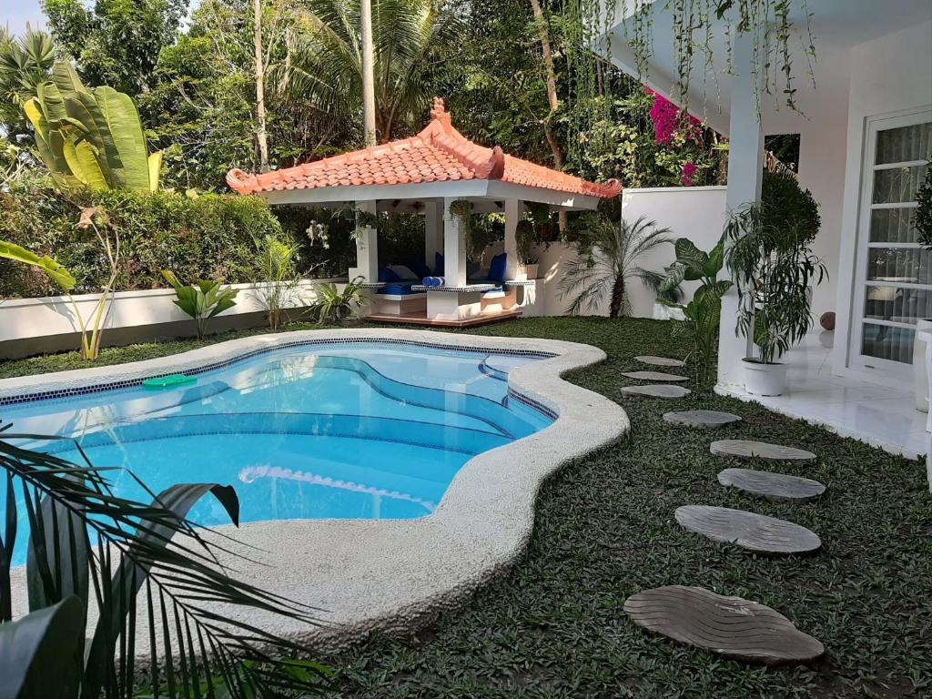 une arrière-cour avec une piscine et un kiosque dans l'établissement SUNKISS VILLA by Yogya Tropicana, à Yogyakarta