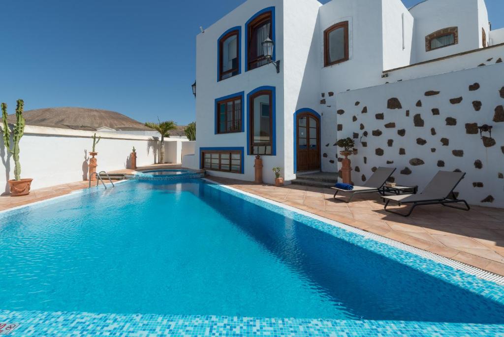 een villa met een zwembad voor een huis bij La Casona de Yaiza in Yaiza
