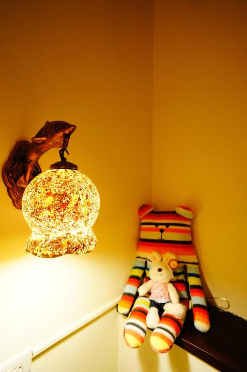 a room with a lamp and a stuffed animal on a shelf at Sweet Rainbow B&amp;B in Hualien City