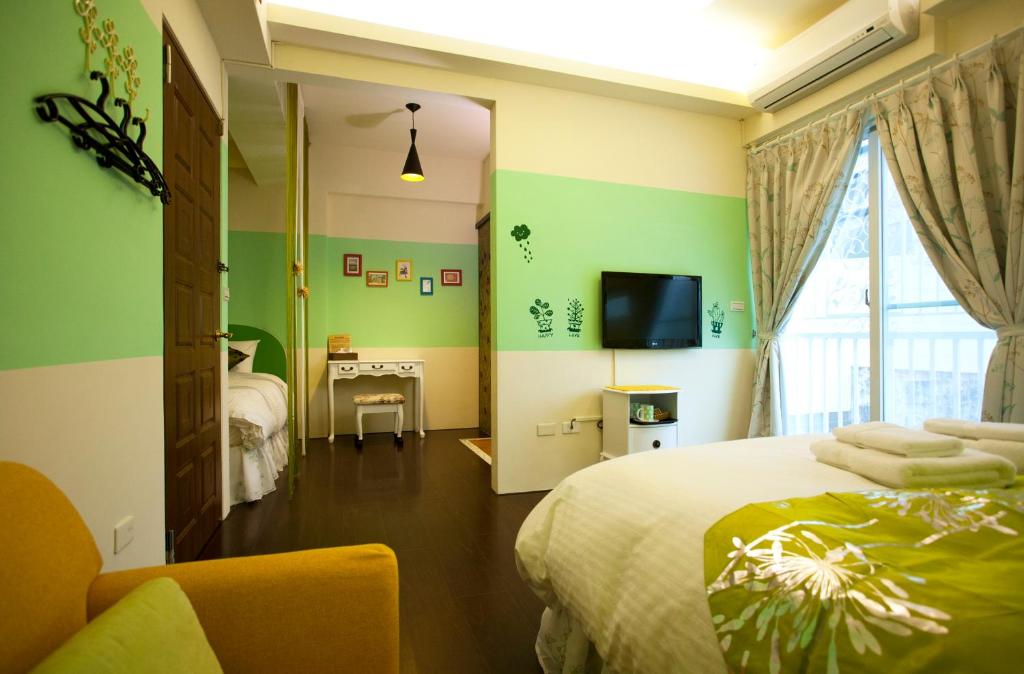 a bedroom with a bed and a tv and a window at Sweet Rainbow B&amp;B in Hualien City