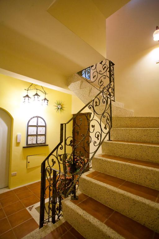 a staircase with a wrought iron railing in a house at Sweet Rainbow B&amp;B in Hualien City