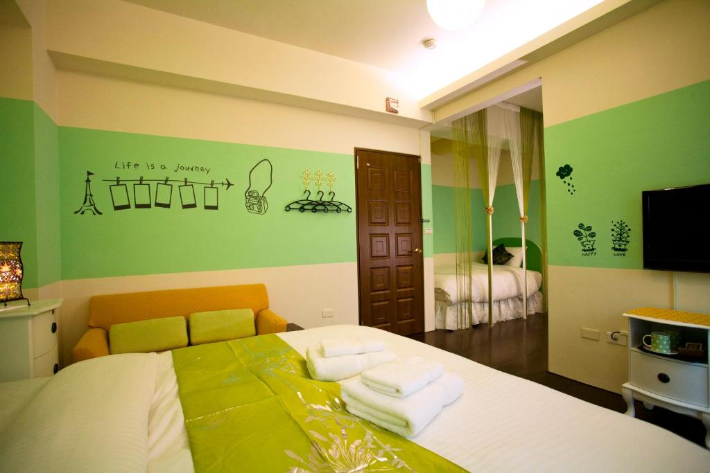 a bedroom with a bed with green walls and a mirror at Sweet Rainbow B&amp;B in Hualien City