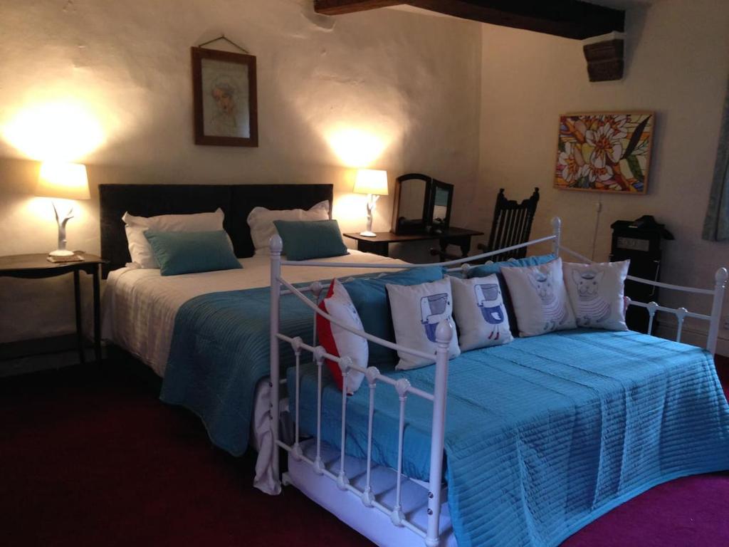 1 dormitorio con 2 camas y almohadas azules y blancas en Riber Hall, en Matlock Bank