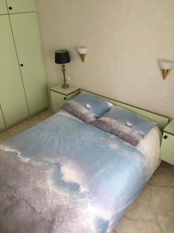 una camera da letto con un grande letto con una coperta blu di Koksijde-bad de block zeelaan C6 a Koksijde