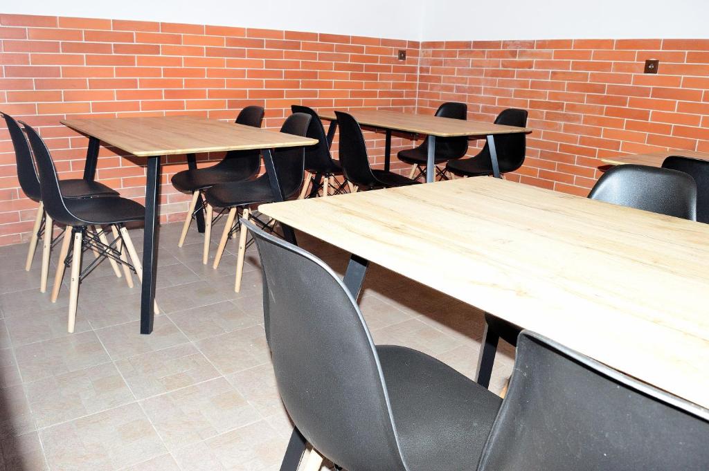 rząd drewnianych stołów i krzeseł w pokoju w obiekcie Apartmán s vinným sklepem Four Grapes w mieście Jevišovka