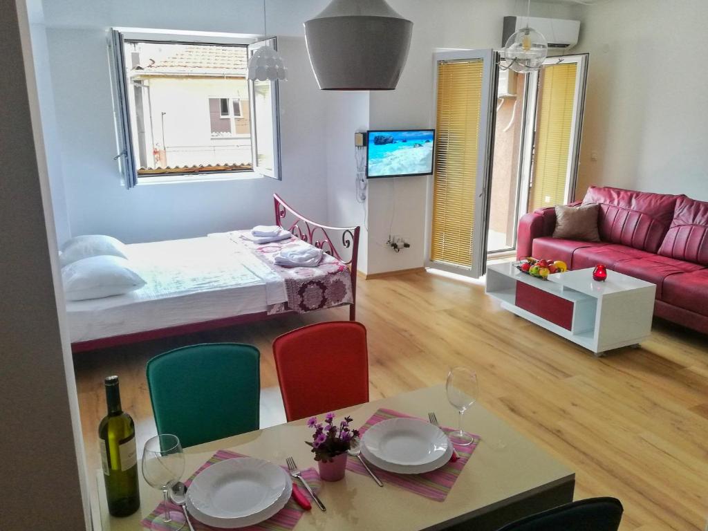 a living room with a bed and a table and chairs at Apartment Maris in Ohrid
