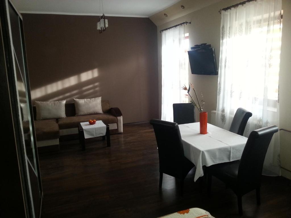 een woonkamer met een tafel en een bank bij Pod Sarenką in Szczawnica