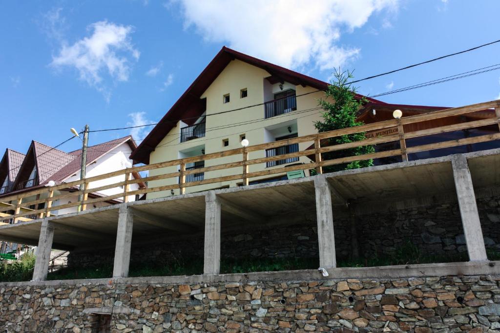 a house on top of a stone wall at Perla Munților in Ranca