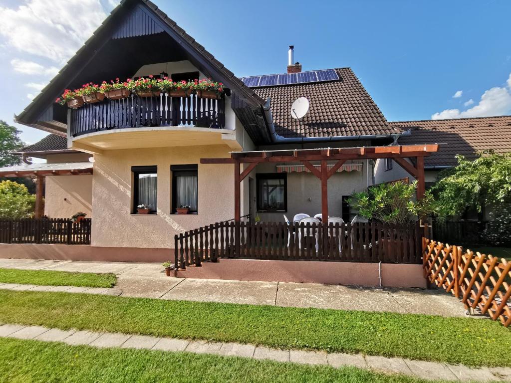 a house with a balcony with flowers on it at Erika Apartman Klímával in Balatonkeresztúr