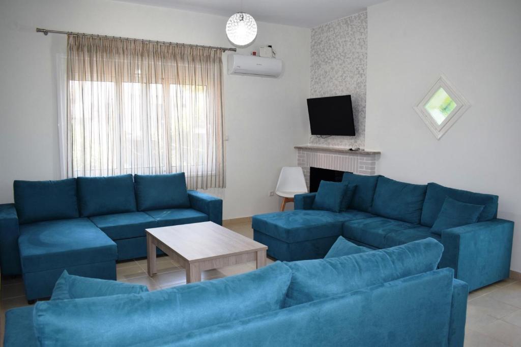 salon z niebieskimi kanapami i telewizorem w obiekcie Villa Giovasia in Tolo w mieście Tolo