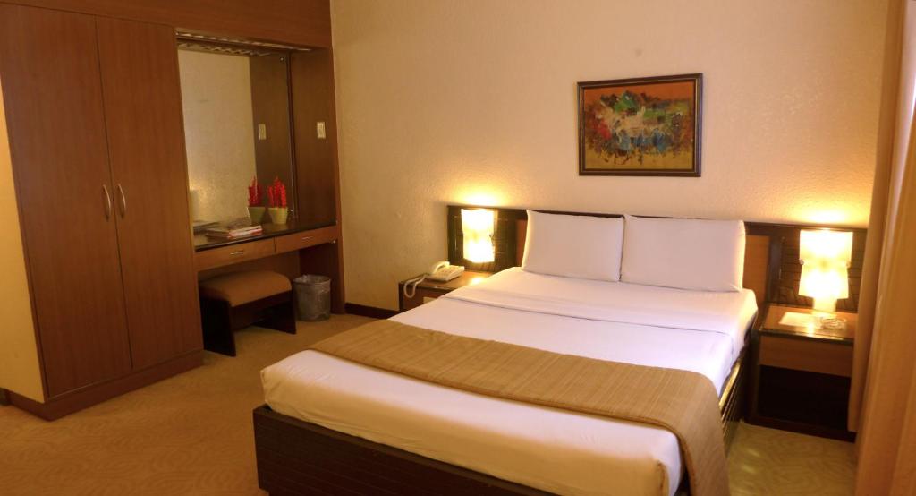 a bedroom with a large bed in a hotel room at Rothman Hotel in Manila