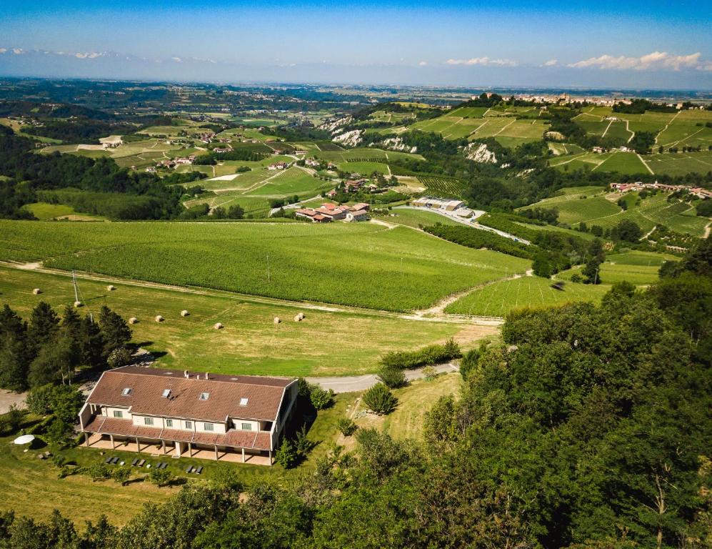 una vista aérea de una granja con una casa en un campo en LE SETTE VIE HOLIDAY HOMES en Monforte dʼAlba