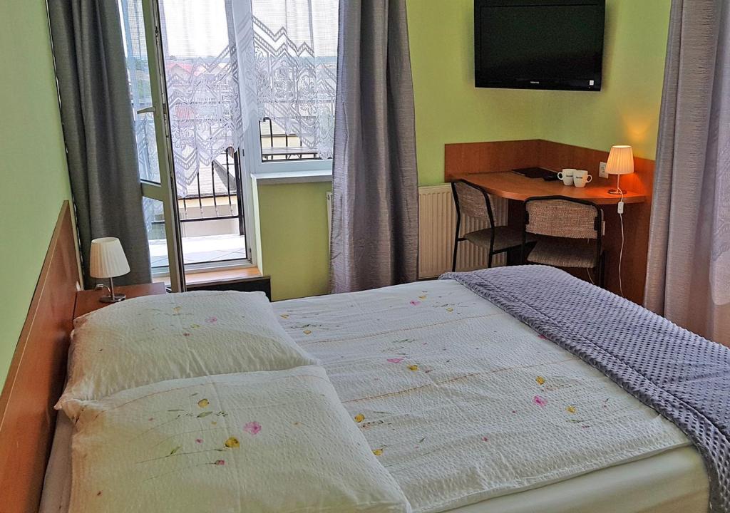 sypialnia z łóżkiem, stołem i oknem w obiekcie Willa Wladek we Władysławowie