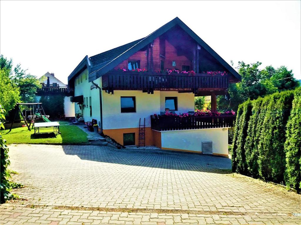 ein Haus mit einem Balkon mit Blumen darauf in der Unterkunft Haus Taekema Appartments in Glanegg