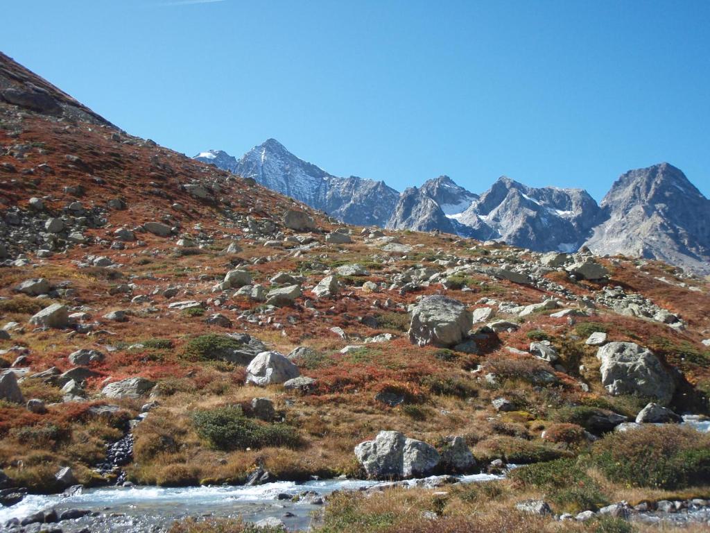 een rotsachtige berg met een beek op de voorgrond bij Les Montagnettes in Les Orres