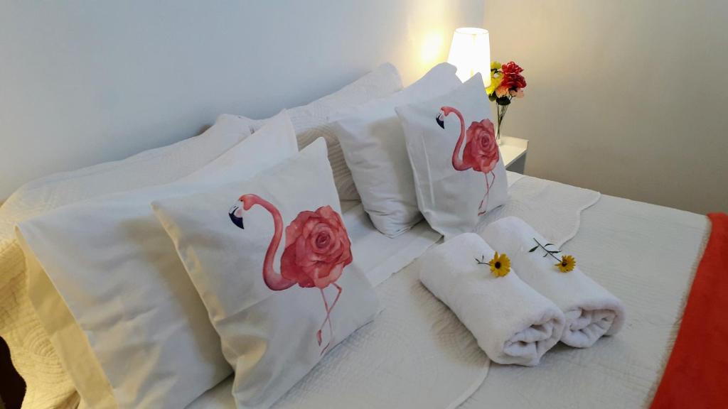 a bed with white pillows with pink flamingos on it at La Palma in Viña del Mar