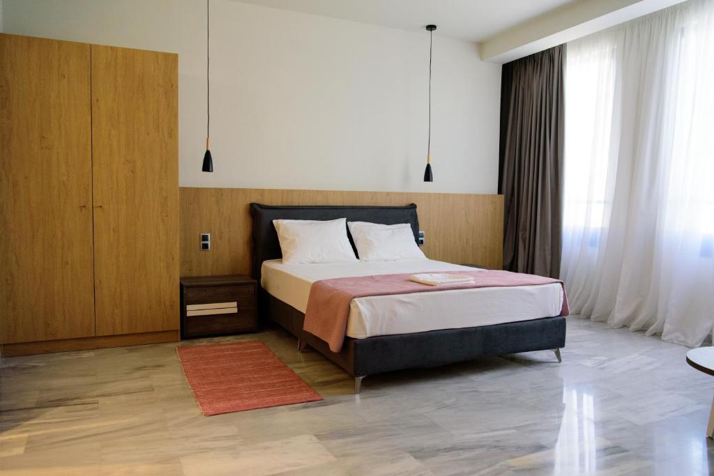 a bedroom with a bed and a dresser at Eva Apartments in Piraeus