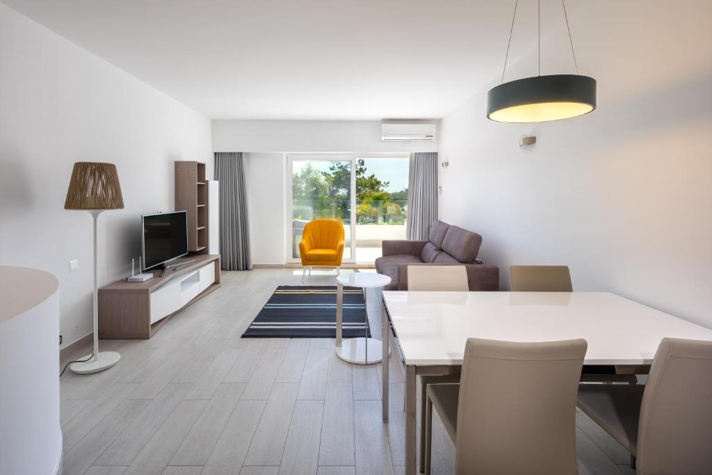 a living room with a dining table and a couch at Victory Village Sea Views in Quinta do Lago