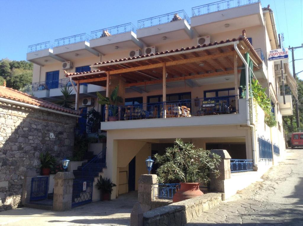 a building with a balcony with people on it at Gorgona Hotel in Skála Sykaminéas