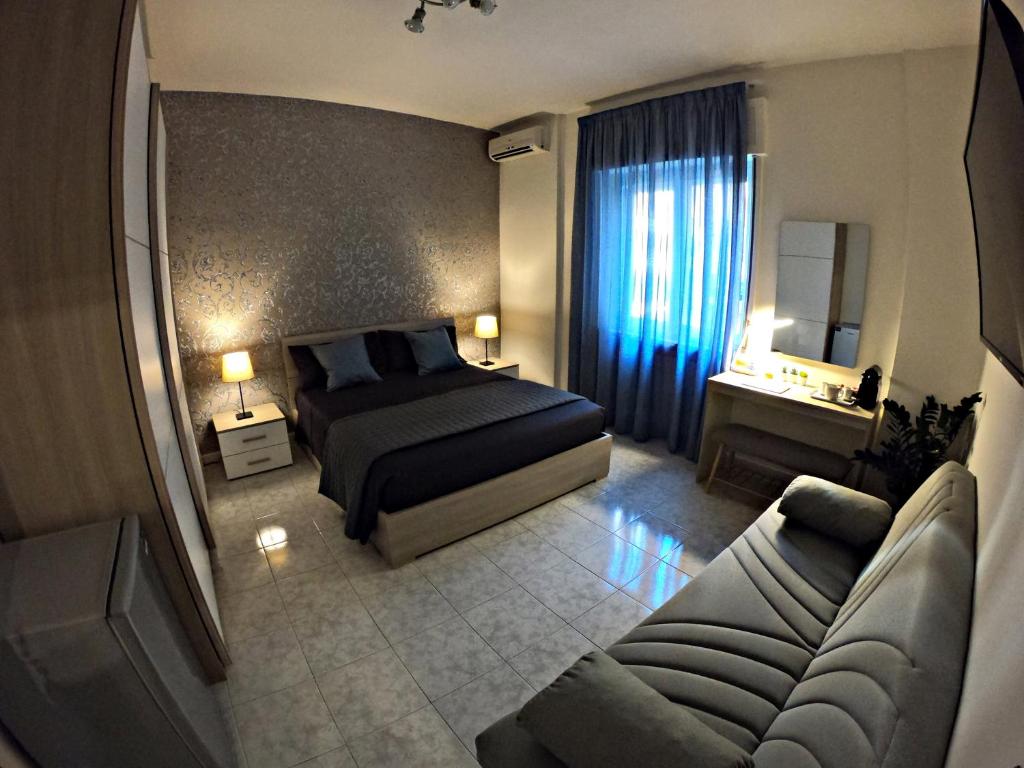 une chambre d'hôtel avec un lit et un canapé dans l'établissement PINOTTO BNB, à Torre Annunziata