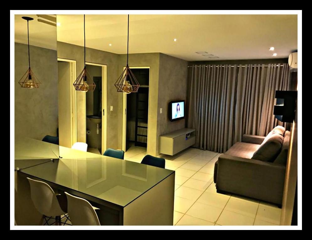 a living room with a glass table and a couch at Apto ALTO PADRÃO em Maceió in Maceió