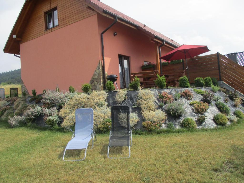 two chairs and a table in front of a house at Ranczo pod Klimoską in Rzyki