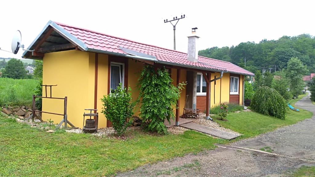 une petite maison jaune sur le côté d'une route dans l'établissement prázdninový domeček Zlámanka, à Kroměříž
