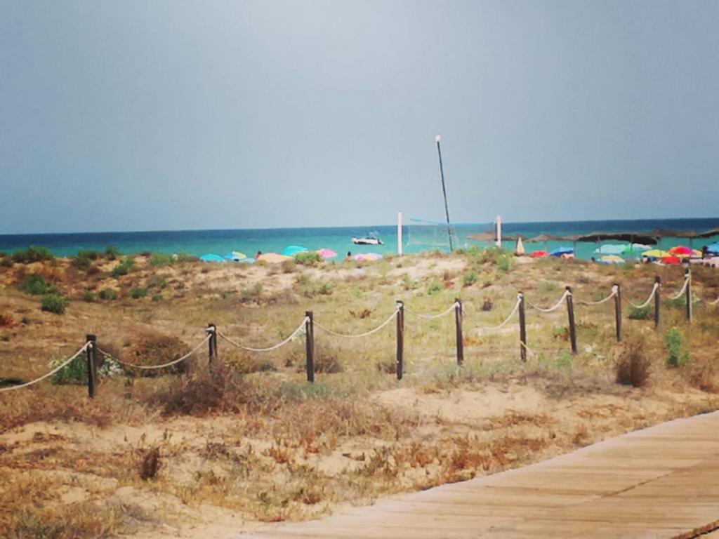 une clôture sur une plage avec l'océan en arrière-plan dans l'établissement Apartamento playa Canet de Berenguer, à Canet d'En Berenguer
