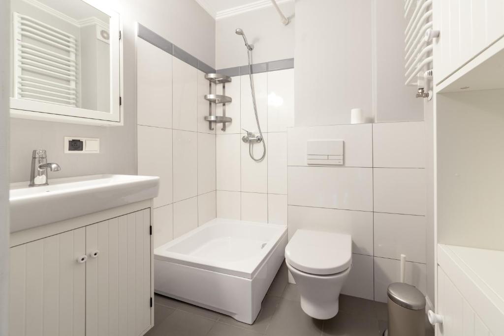 a white bathroom with a toilet and a sink at Boleslav Home in Sucha Beskidzka